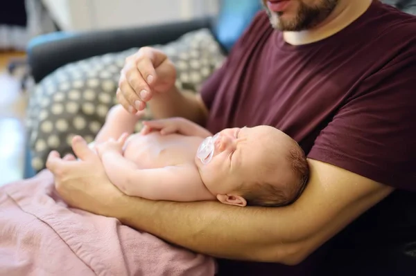 かわいい新生児が父親の腕の中に横たわっていた 父は冷笑の間に泣く新生児を慰める方法を知らない 子育ての難しさ — ストック写真