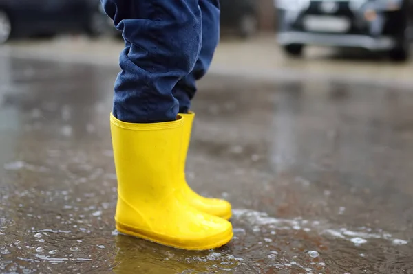 Kleine Jongen Met Gele Rubberen Laarzen Springend Een Plas Water — Stockfoto