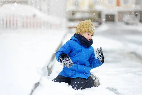 雪の中で新雪と遊ぶのが楽しい男の子 暖かい服 手の手袋 スカーフで身を包んだ子供 雪の冬の日に自然の中で子供のためのアクティブな屋外レジャー — ストック写真