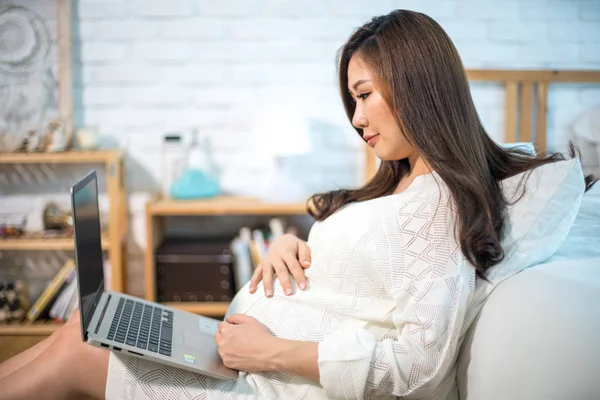 W ciąży Asian kobieta za pomocą laptop — Zdjęcie stockowe