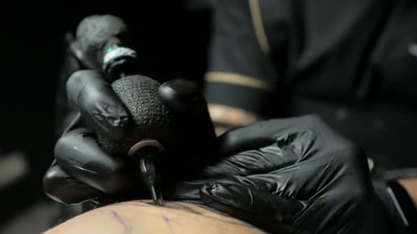 Tattoo artist makes a tattoo on a mans hand