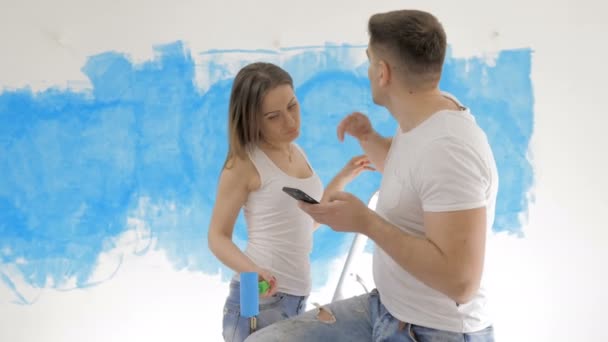 Couple talking about interior design on the background of painted wall — Stock Footage Couple talking about interior design on the background of painted wall Royalty Free Stock Footage