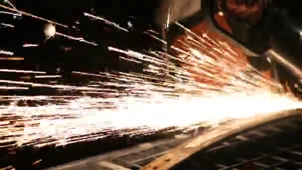 Vousatý mechanik řeže kov s úhlovou bruskou na čerpací stanici