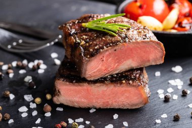 Biftek üst bıçak kavurma orta taş koyu arka plan üzerinde yemeye hazır Close-up