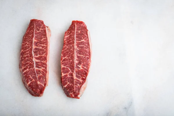Syrové maso Top Blade steaky na světlé pozadí. pohled shora s kopií prostor — Stock fotografie