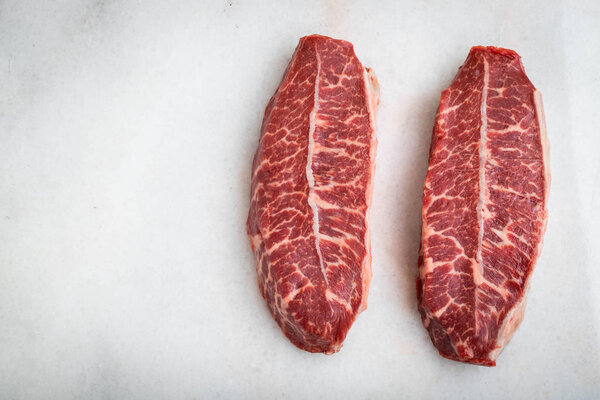 Raw fresh meat Top Blade steaks on light background. top view with copy space