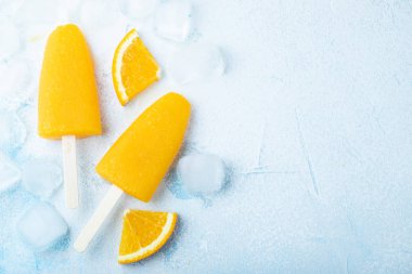 Mavi bacground suyu ile turuncu çubuklu dondurmayı. Buz açılır, kopya alanı düz yatıyordu, en iyi manzaralı