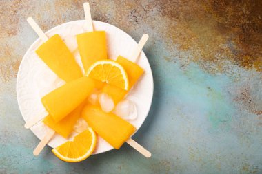 Mavi bacground suyu ile turuncu çubuklu dondurmayı. Buz açılır, kopya alanı düz yatıyordu, en iyi manzaralı.