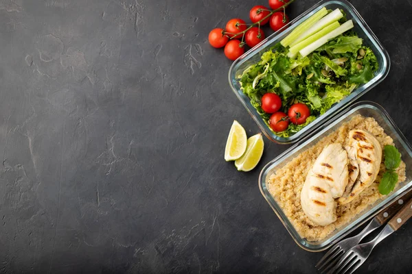 Healthy meal prep containers with quinoa, chicken breast and green salad overhead shot with copy space. Top view. Flat lay.