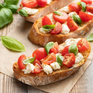 Bruschetta domates, mozzarella peyniri ve fesleğen eski bir rustik tablo. Geleneksel İtalyan meze veya aperatif, meze.