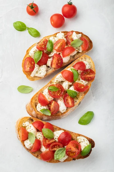 Bruschetta Con Tomates Queso Mozzarella Albahaca Sobre Fondo Claro Aperitivo —  Fotos de Stock