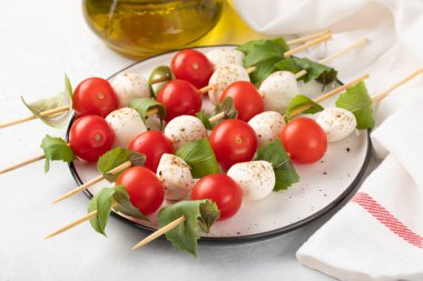 Caprese salatası - şiş domates, mozzarella ve fesleğen, İtalyan gıda ve sağlıklı vejetaryen diyet kavramı üzerinde hafif bir arka plan ile.