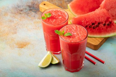 Karpuz meybuz kireç ile yaz ferahlatıcı içeceği paslı mavi bir arka plan üzerinde uzun boylu gözlük olarak. kopya alanı ile.