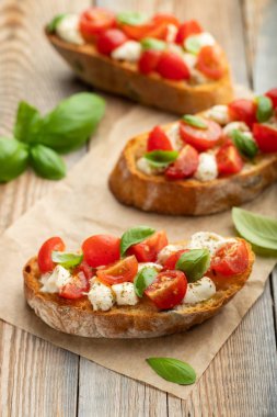 Bruschetta domates, mozzarella peyniri ve fesleğen eski bir rustik tablo. Geleneksel İtalyan meze veya aperatif, meze.