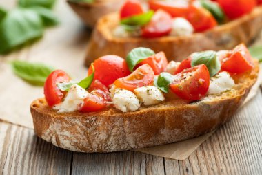 Bruschetta domates, mozzarella peyniri ve fesleğen eski bir rustik tablo. Geleneksel İtalyan meze veya aperatif, meze.