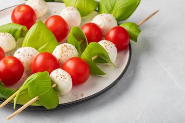 Caprese salatası - şiş domates, mozzarella ve fesleğen, İtalyan gıda ve sağlıklı vejetaryen diyet kavramı üzerinde hafif bir arka plan ile.