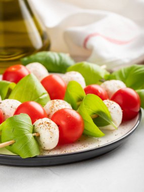Caprese salatası - şiş domates, mozzarella ve fesleğen, İtalyan gıda ve sağlıklı vejetaryen diyet kavramı üzerinde hafif bir arka plan ile.
