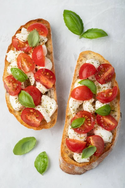 Bruschetta Com Tomates Queijo Mussarela Manjericão Sobre Fundo Claro Aperitivo — Fotografia de Stock