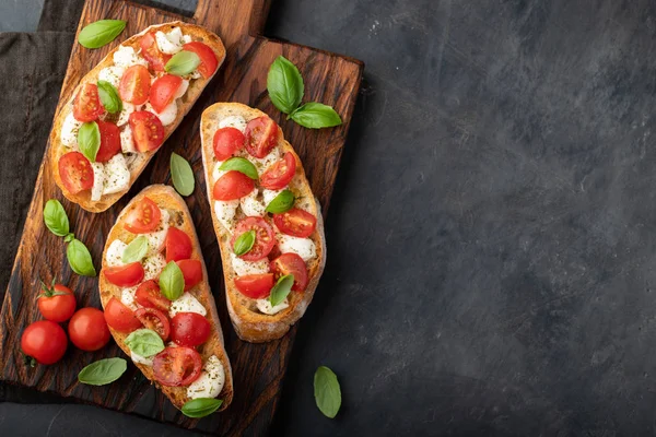 Bruschetta Con Tomates Queso Mozzarella Albahaca Una Tabla Cortar Aperitivo — Foto de Stock