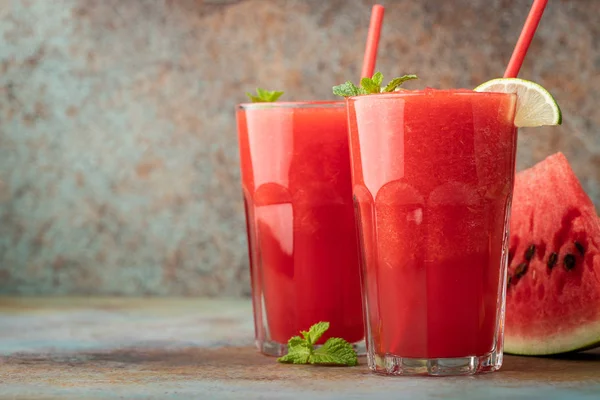 Watermeloen slushie met kalk, verfrissend drankje van de zomer in hoge glazen op een blauwe achtergrond van roestig. met kopie ruimte — Stockfoto