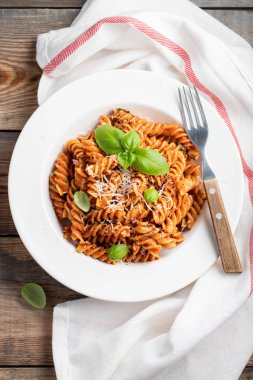 Düdük makarna domates sosu, sarımsak, fesleğen ve Parmesan peyniri eski ahşap masa. Üstten görünüm. Düz yatıyordu.