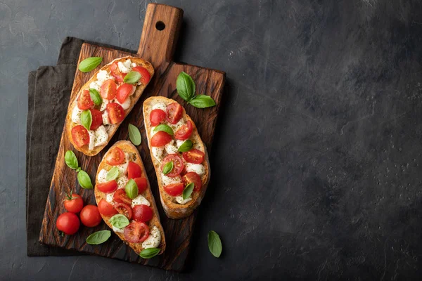 Bruschetta Com Tomates Queijo Mussarela Manjericão Uma Tábua Corte Aperitivo — Fotografia de Stock