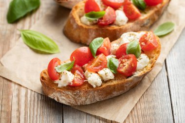 Bruschetta domates, mozzarella peyniri ve fesleğen eski bir rustik tablo. Geleneksel İtalyan meze veya aperatif, meze.