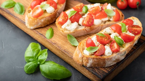 Bruschetta Con Tomates Queso Mozzarella Albahaca Una Tabla Cortar Aperitivo —  Fotos de Stock