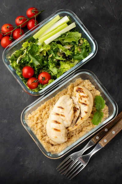 Healthy meal prep containers with quinoa, chicken breast and green salad overhead shot. Top view. Flat lay.