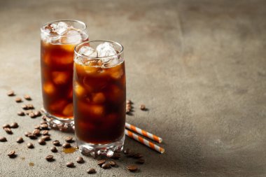 Krem üzerine dökülür ve kahve çekirdekleri ile uzun bir bardak buzlu kahve. Soğuk yaz içeceği kopya alanı kahverengi bir paslı zemin üzerine.