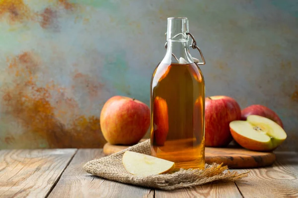 Cuka apel. Sebotol cuka organik apel atau sari buah apel dengan latar belakang kayu. Makanan organik sehat. Dengan ruang fotokopi — Stok Foto