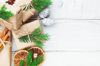 Noel kompozisyonu. Noel hediyesi, çam kozalakları, tahta beyaz arka planda köknar dalları. Düz konum, üst görünüm, kopyalama alanı.
