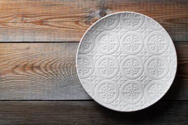 Güzel boş beyaz plaka üzerinde koyu ahşap masa süsleme ile. Üstten görünüm kopya alanı ile. Düz yatıyordu