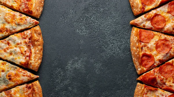 Разрежьте на кусочки вкусную свежую пиццу пепперони и пиццу четыре сыра на темном фоне. Вид сверху с пространством для копирования текста. Пицца на черном бетонном столе. Плоская постель — стоковое фото