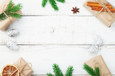 Noel kompozisyonu. Noel hediyesi, çam kozalakları, tahta beyaz arka planda köknar dalları. Düz konum, üst görünüm, kopyalama alanı.