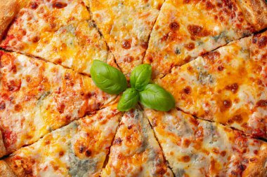Fesleğen, domates ve karanlık bir beton masaya zeytin yağı ile lezzetli İtalyan pizza dört peynir. Üstten görünüm.