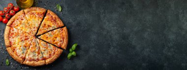 Fesleğen, domates ve karanlık bir beton masaya zeytin yağı ile lezzetli İtalyan pizza dört peynir. Üstten görünüm kopya alanı ile. Düz yatıyordu. afiş.