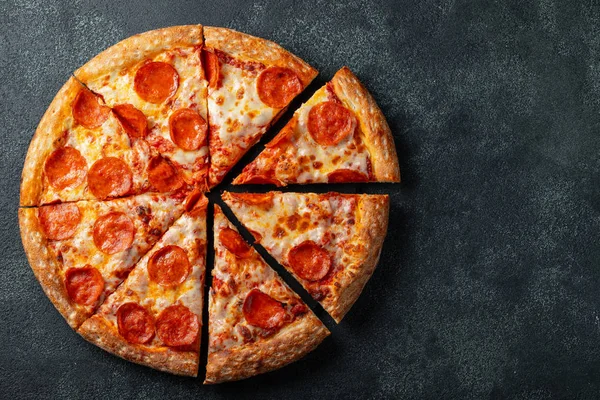 Lezzetli biberli pizza ve siyah beton arka planda domates fesleğeni. Acı biberli pizzanın en iyi manzarası. Metin için kopyalama alanı ile. Düz yatıyordu.