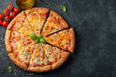 Fesleğen, domates ve karanlık bir beton masaya zeytin yağı ile lezzetli İtalyan pizza dört peynir. Üstten görünüm kopya alanı ile. Düz yatıyordu.