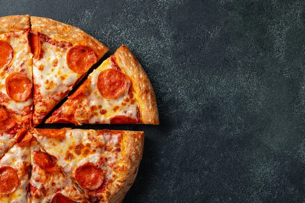 Lezzetli biberli pizza ve siyah beton arka planda domates fesleğeni. Acı biberli pizzanın en iyi manzarası. Metin için kopyalama alanı ile. Düz yatıyordu