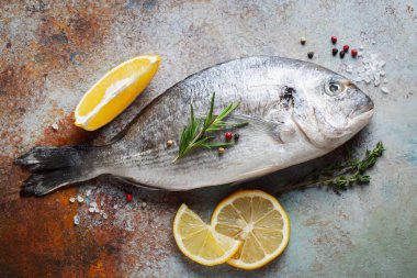Baharat ve mavi bir paslı masaya zeytin yağı ile taze çiğ Dorado balık. Üstten görünüm. Düz yatıyordu.