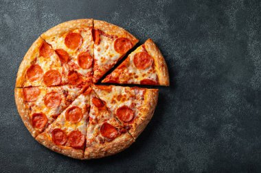 Lezzetli biberli pizza ve siyah beton arka planda domates fesleğeni. Acı biberli pizzanın en iyi manzarası. Metin için kopyalama alanı ile. Düz yatıyordu.