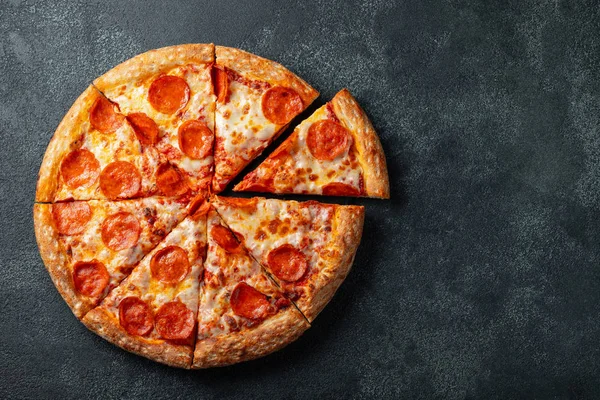 Lezzetli biberli pizza ve siyah beton arka planda domates fesleğeni. Acı biberli pizzanın en iyi manzarası. Metin için kopyalama alanı ile. Düz yatıyordu.