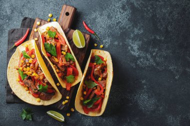 Et, sebze ve salsa Meksika Taco. Siyah arka plan üzerine ahşap tahta üzerinde Tacos al papazı. Kopya alanı ile üstten görünüm.