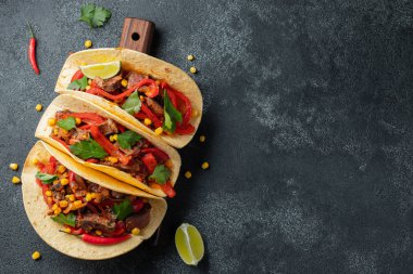 Et, sebze ve salsa Meksika Taco. Siyah arka plan üzerine ahşap tahta üzerinde Tacos al papazı. Kopya alanı ile üstten görünüm.
