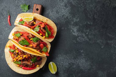 Et, sebze ve salsa Meksika Taco. Siyah arka plan üzerine ahşap tahta üzerinde Tacos al papazı. Kopya alanı ile üstten görünüm