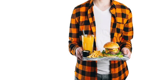 一名身穿格子橙色衬衫的男生 身穿白色背景的格子橙衬衫 拿着一块木板 上面有一个新鲜的汉堡 一杯橙汁和炸土豆 具有文本的复制空间 — 图库照片