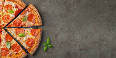 Fesleğenli kahverengi beton zemin üzerine lezzetli biberli pizza. Üstten görünüm sıcak biberli pizza. Metin için kopya yer ile. Düz yatıyordu.