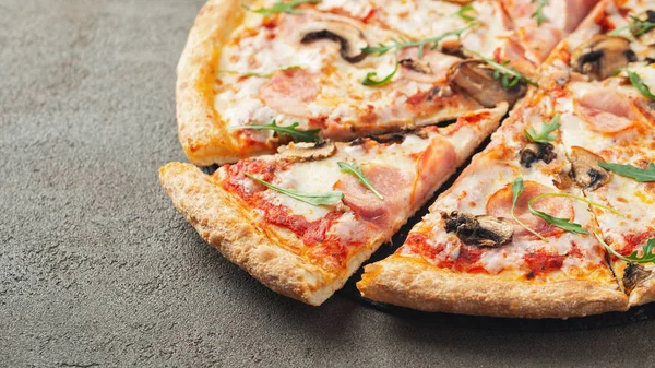 İtalyan Lokanta. Lezzetli sıcak pizza jambon ve dilimlenmiş ve kahverengi beton masaya servis petrol görünümü kapatın. Menü fotoğraf.