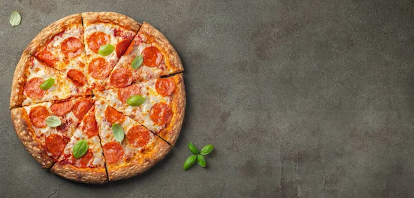 Fesleğenli kahverengi beton zemin üzerine lezzetli biberli pizza. Üstten görünüm sıcak biberli pizza. Metin için kopya yer ile. Düz yatıyordu.
